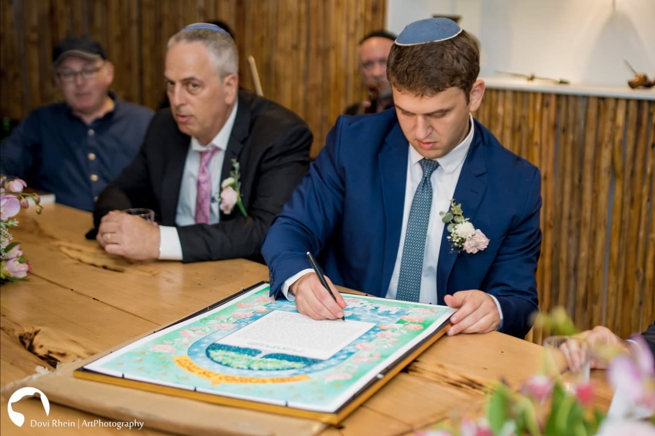 החתן חותם על הכתובה